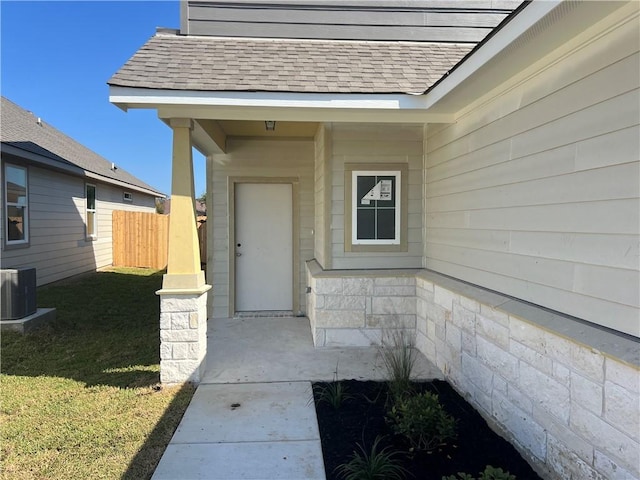 doorway to property with a lawn and central air condition unit