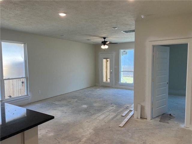 interior space featuring ceiling fan and a textured ceiling