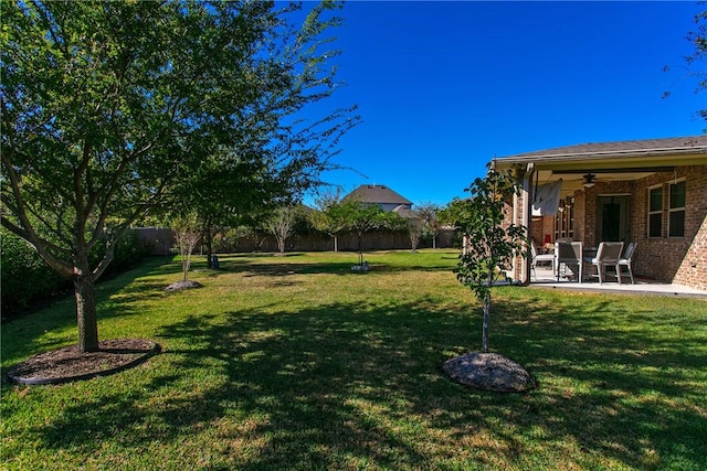 view of yard featuring ceiling fan, a fenced backyard, and a patio