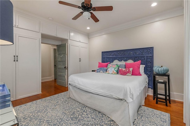 bedroom featuring ceiling fan, dark hardwood / wood-style floors, ornamental molding, and a closet