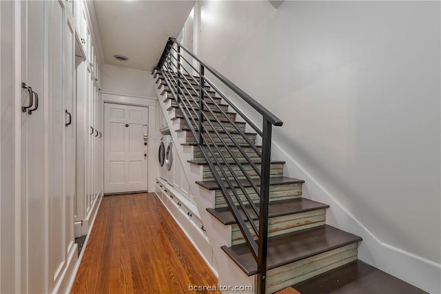 staircase featuring hardwood / wood-style floors and independent washer and dryer