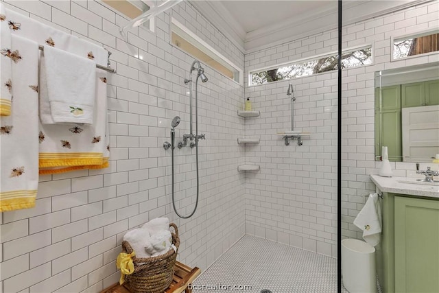 bathroom with vanity, ornamental molding, tiled shower, and tile walls