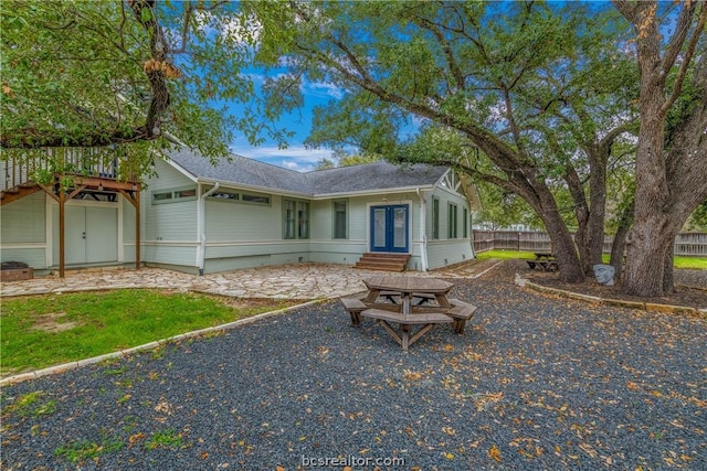 view of front of property featuring a wooden deck, french doors, and a patio