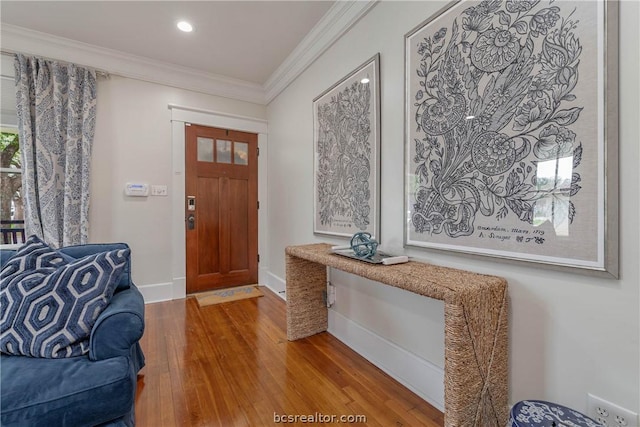 entrance foyer with crown molding and hardwood / wood-style flooring