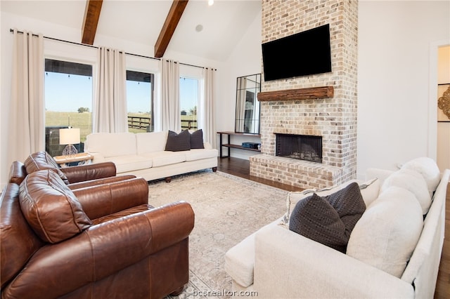 living room with hardwood / wood-style flooring, beamed ceiling, high vaulted ceiling, and a brick fireplace