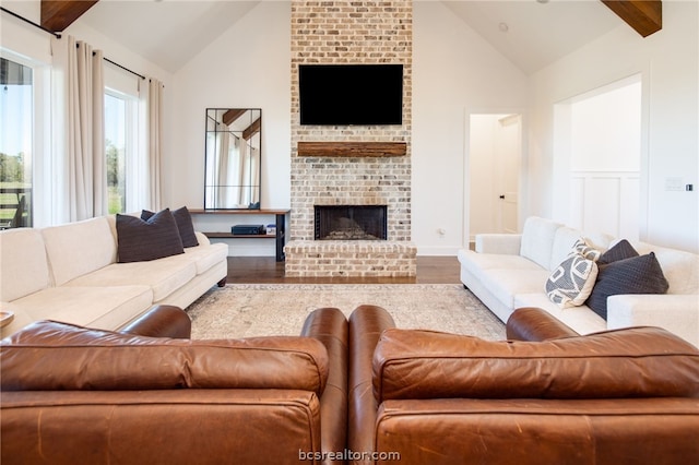 living room with a fireplace, high vaulted ceiling, wood-type flooring, and beamed ceiling