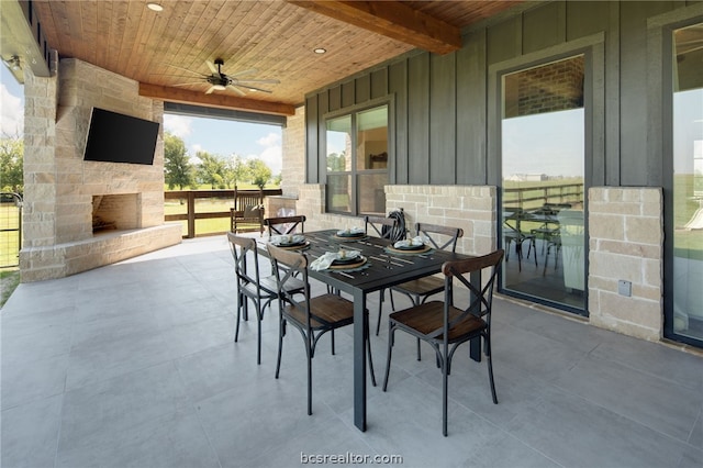 view of patio / terrace featuring an outdoor stone fireplace and ceiling fan