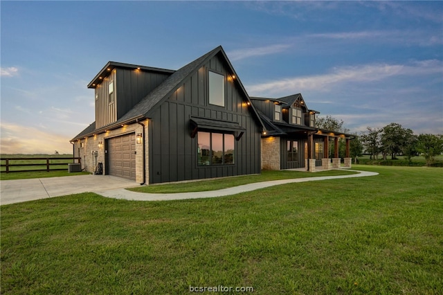 property exterior at dusk with a garage and a lawn