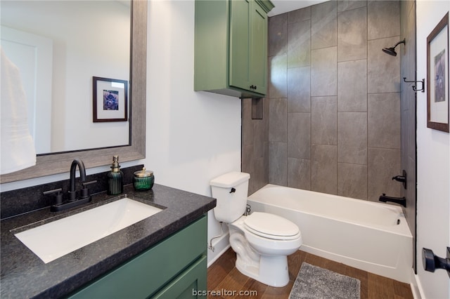 full bathroom featuring vanity, wood-type flooring, tiled shower / bath combo, and toilet