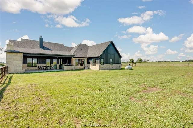 rear view of property featuring a yard and a patio