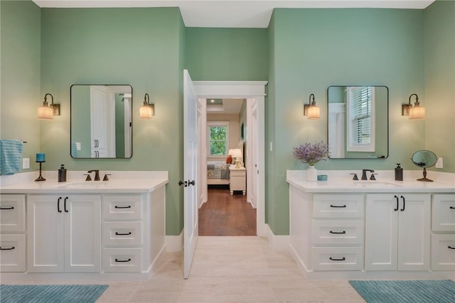 5026 Yellow Tanager Ct, College Station, TX 77845 - ensuite bathroom with baseboards, two vanities, and wood finished floors