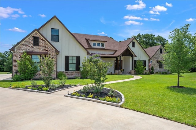 5026 Yellow Tanager Ct, College Station, TX 77845 - view of front facade featuring board and batten siding, brick siding, a front yard, and a shingled roof