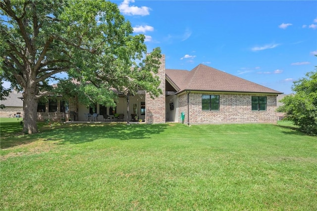 5026 Yellow Tanager Ct, College Station, TX 77845 - rear view of house featuring brick siding, a yard, a chimney, and a shingled roof