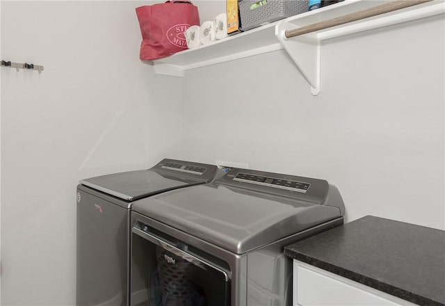 clothes washing area with washing machine and dryer