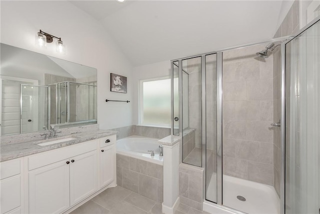 bathroom featuring tile patterned floors, separate shower and tub, vanity, and lofted ceiling