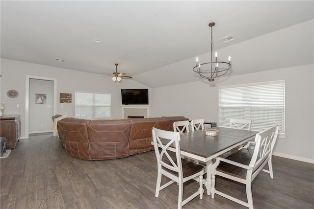 dining area featuring dark hardwood / wood-style flooring, ceiling fan with notable chandelier, and lofted ceiling