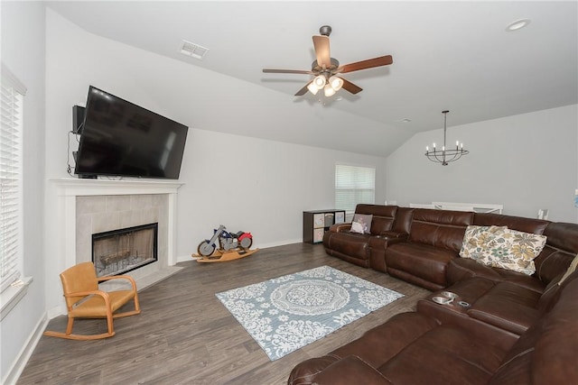 living room featuring plenty of natural light, lofted ceiling, a fireplace, and dark wood-type flooring