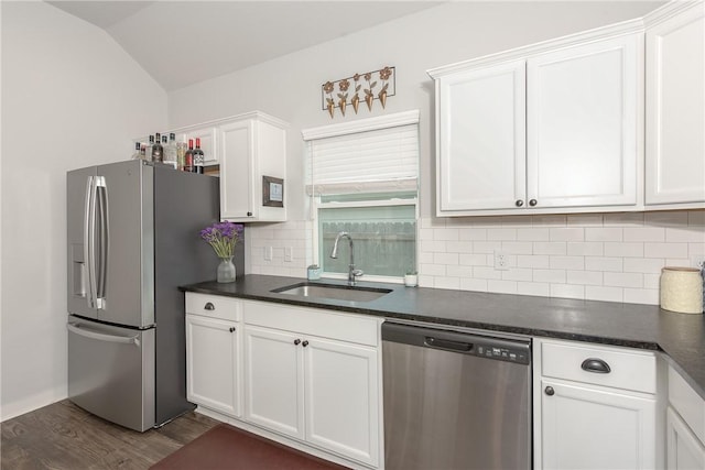 kitchen with white cabinets, sink, vaulted ceiling, dark hardwood / wood-style floors, and stainless steel appliances