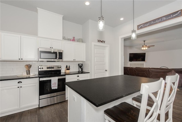 kitchen featuring white cabinetry, ceiling fan, pendant lighting, and appliances with stainless steel finishes