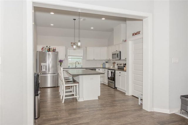 kitchen featuring sink, a kitchen island, pendant lighting, white cabinets, and appliances with stainless steel finishes