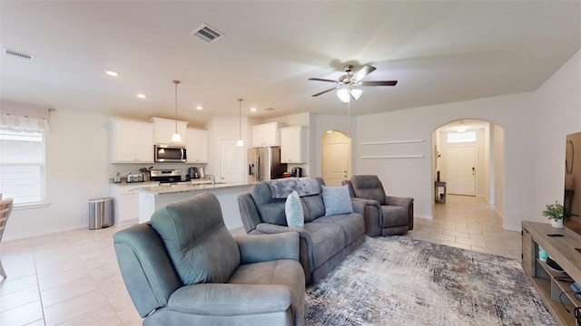 1924 Cartwright St, Bryan, TX 77807 - living area with arched walkways, light tile patterned flooring, ceiling fan, baseboards, and recessed lighting