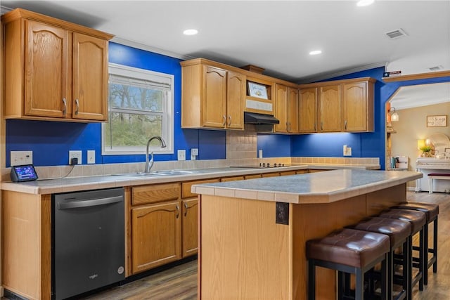 kitchen with stainless steel dishwasher, dark hardwood / wood-style floors, a kitchen island, and a breakfast bar area