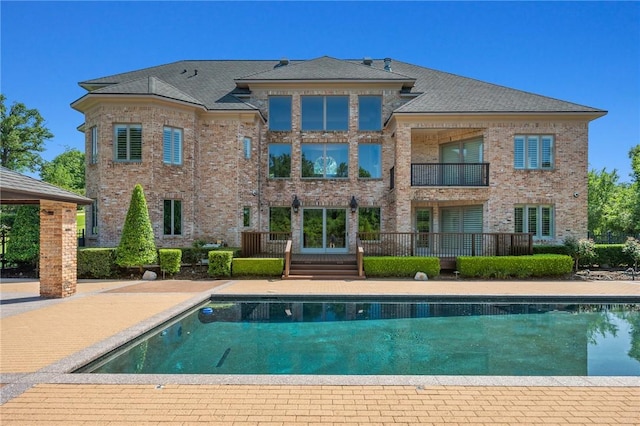 4727 Johnson Creek Loop, College Station, TX 77845 - back of house with brick siding, a balcony, and an outdoor pool