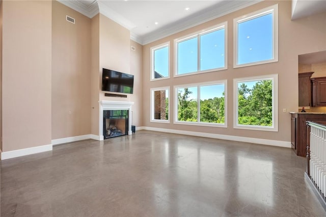 4727 Johnson Creek Loop, College Station, TX 77845 - unfurnished living room with a towering ceiling, baseboards, a tile fireplace, finished concrete flooring, and crown molding