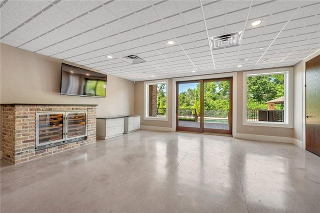 4727 Johnson Creek Loop, College Station, TX 77845 - unfurnished living room with finished concrete floors, baseboards, recessed lighting, and a drop ceiling