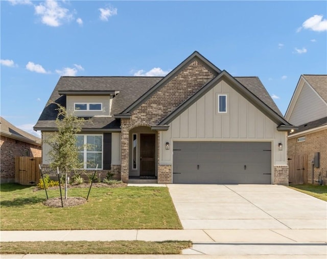 craftsman-style home featuring a front yard, fence, an attached garage, concrete driveway, and brick siding