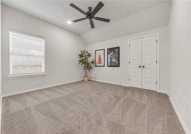 unfurnished room featuring carpet floors, vaulted ceiling, and ceiling fan