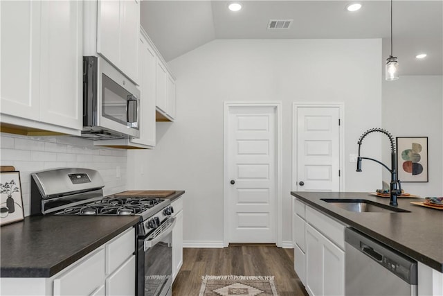 kitchen with appliances with stainless steel finishes, white cabinetry, hanging light fixtures, and sink