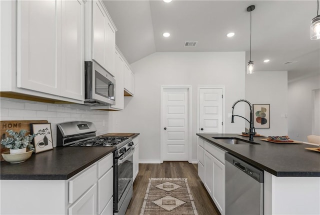 kitchen featuring lofted ceiling, white cabinets, sink, hanging light fixtures, and stainless steel appliances