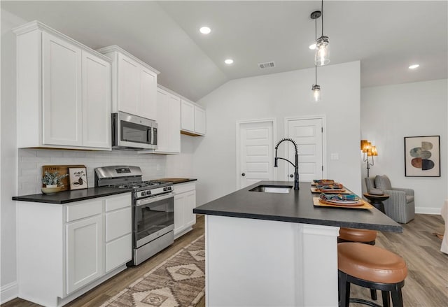 kitchen featuring a center island with sink, white cabinets, sink, and appliances with stainless steel finishes