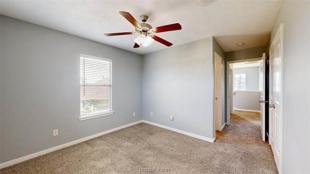 empty room featuring ceiling fan and light carpet