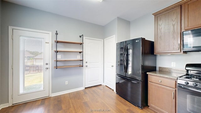 kitchen with light wood-type flooring and black appliances