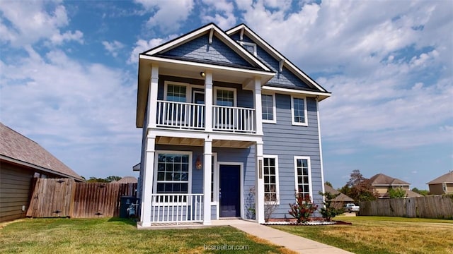 view of front of house featuring a balcony and a front yard