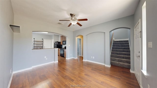 unfurnished living room featuring ceiling fan and hardwood / wood-style floors