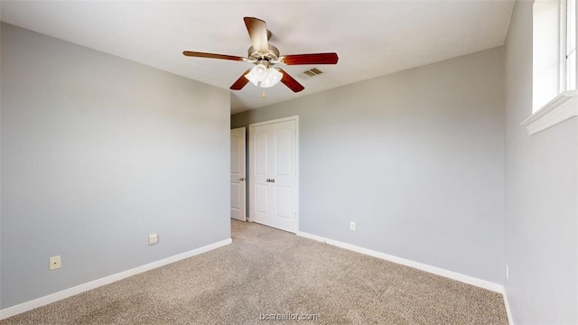 carpeted spare room with ceiling fan