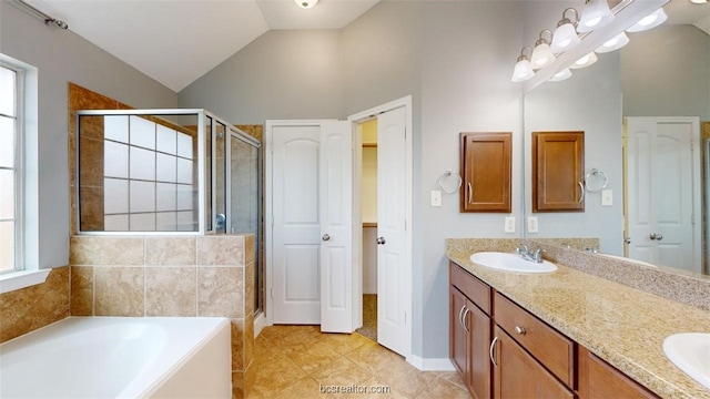 bathroom with vanity, a wealth of natural light, vaulted ceiling, and plus walk in shower