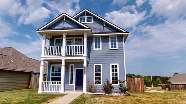 view of front of home featuring a balcony and a front lawn