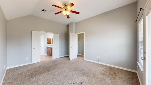 unfurnished bedroom featuring lofted ceiling, light colored carpet, ceiling fan, and connected bathroom