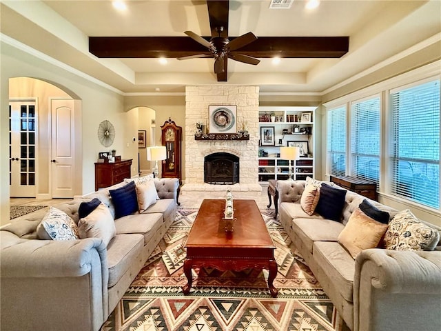 3204 Ashville Path, Bryan, TX 77808 - living room with arched walkways, a ceiling fan, beamed ceiling, a fireplace, and recessed lighting