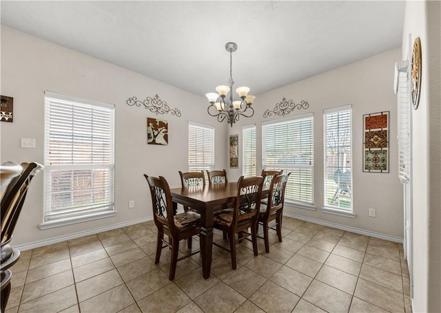 tiled dining area featuring a healthy amount of sunlight and a chandelier