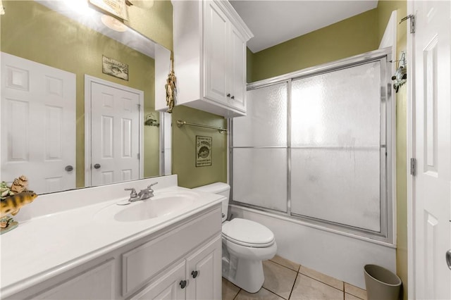 full bathroom featuring tile patterned flooring, vanity, toilet, and combined bath / shower with glass door