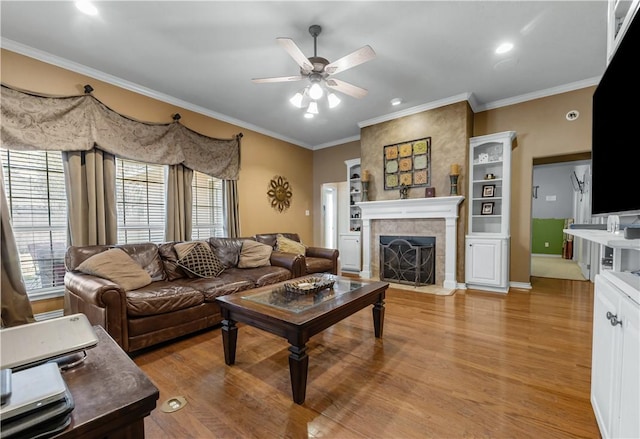 living room featuring a tile fireplace, hardwood / wood-style flooring, and ornamental molding