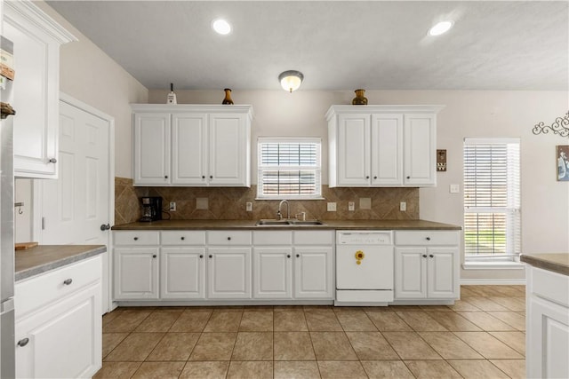 kitchen with white cabinetry, sink, white dishwasher, and light tile patterned flooring