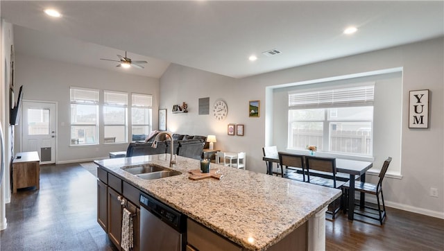 kitchen featuring baseboards, open floor plan, stainless steel dishwasher, a ceiling fan, and a sink