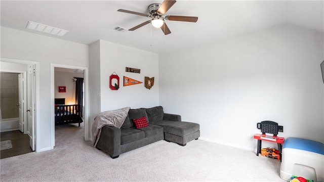 living area featuring visible vents, lofted ceiling, carpet floors, baseboards, and ceiling fan