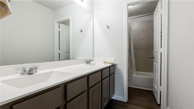 bathroom with double vanity, shower / tub combo, wood finished floors, and a sink